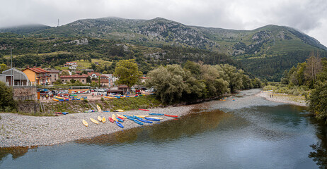 Vistas del río Deba a su paso por Unquera en Cantabria, con canoas de colores en su orilla, verano...