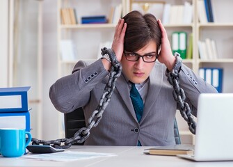 Businessman tied with chains to his work