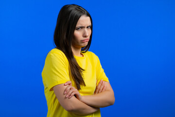 Angry offended woman keeping arms crossed and staring at camera with sceptical look, feeling mad at...