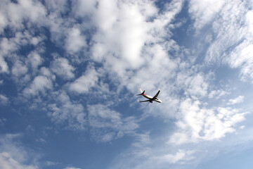 Plane taking off from the runway, flying through the clouds, increasing its height
