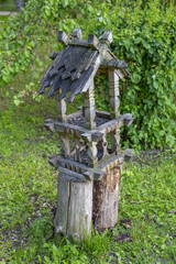 Wooden birdhouse-feeder in the summer city park