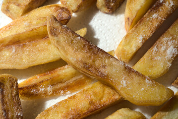 French fries cooked at home lie on a white napkin.