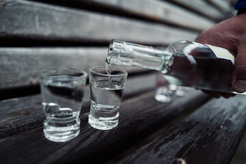 Alkohol einschenken auf einer Holzbank in Wald