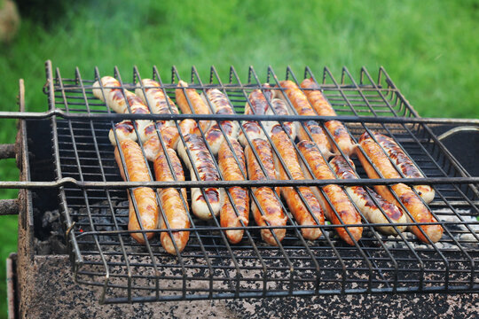 Cooking sausages on the grill. Preparing kupati, georgian sausages. Back yard picnic concept.