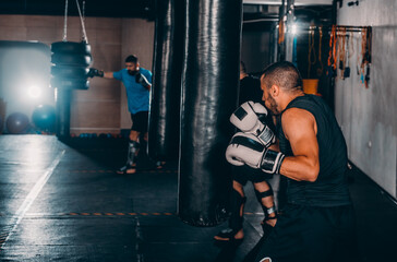 Hispanic MMA Fighter practicing some kicks with a punching bag