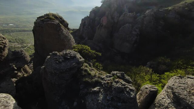 Extreme flight between mountain rocks. Shot. Fast flight at rocky formations on mountain slopes. Fly like wingsuit on rocky slopes of green mountains
