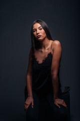 Naklejka premium Passionate portrait of an attractive brunette looking in the camera and posing on dark background in a studio
