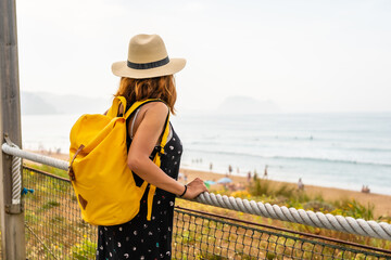 Summer vacation lifestyle. Young adventurous Caucasian girl enjoying summer looking at the sea on...