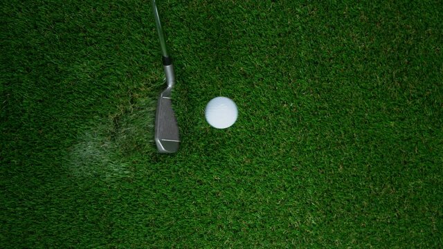 Super slow motion of golf club hitting golf ball on green grass. Filmed on high speed cinematic camera at 1000 fps.