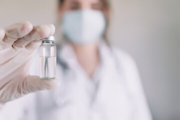 Doctor or nurse is holding glass vial bottle of anti virus vaccine