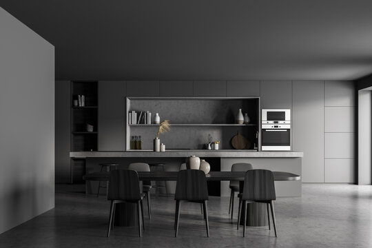 Dark kitchen interior with dining table and chairs on grey floor
