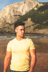 Young caucasian man walking at the beach