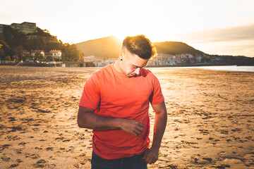 Young caucasian man at Lekeitio beach while sunset
