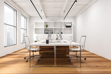 Big computer tables in white open space office, side view