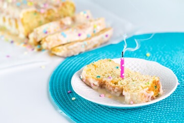 Candle blown out on a slice of confetti loaf cake for a birthday celebration.