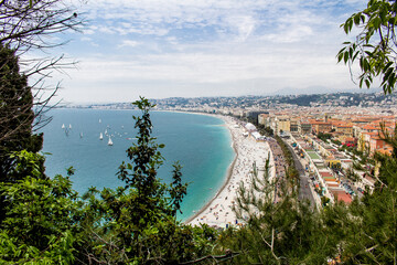 Cadre de verdure avec vue sur une course de voiliers devant la Promenade des Anglais &agrave; Nice