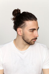 Obraz premium Attractive male model with long hair and beard posing in studio on isolated background. Style, trends, fashion concept.