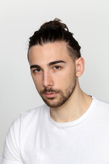 Obraz premium Attractive male model with long hair and beard posing in studio on isolated background. Style, trends, fashion concept.