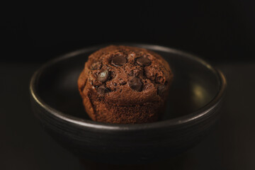 Homemade chocolate chips and vanilla muffin on a black background with sugar