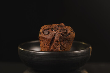 Homemade chocolate chips and vanilla muffin on a black background with sugar