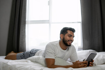 Hombre en videollamada acostado cómodamente en su cama