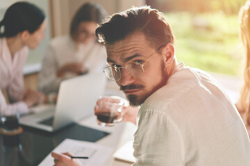 Portrait of successful bearded businessman holding meeting