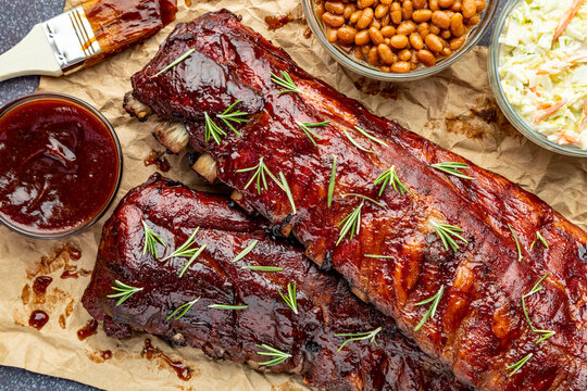 2 slabs of ribs with barbeque sauce on brown paper