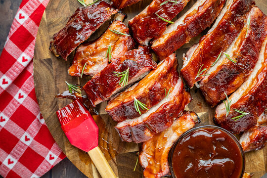 Barbeque ribs sliced on round wooden cutting board