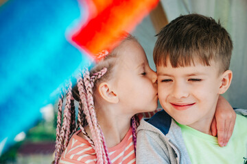 Kids kiss in homemade tent. Backyard party. Best friends spend time. Cute kids camping. Summer fun...