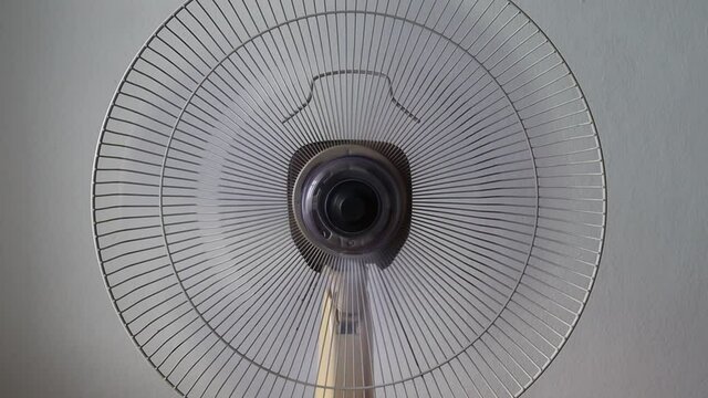 Desktop fan blowing and rotating towards ventilating cool comfortable.