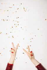 Cool party. Festive background. Holiday celebration. Female hands red dress showing peace gesture...