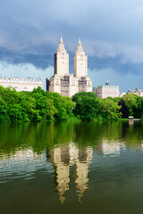 Fototapeta na wymiar Upper West Side Skyline reflects in the lake of Central Park, New York City. Storm clouds.