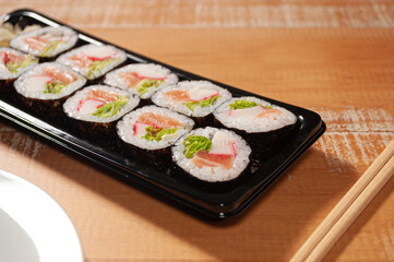 A sushi bar, a pair of chopsticks and a white plate