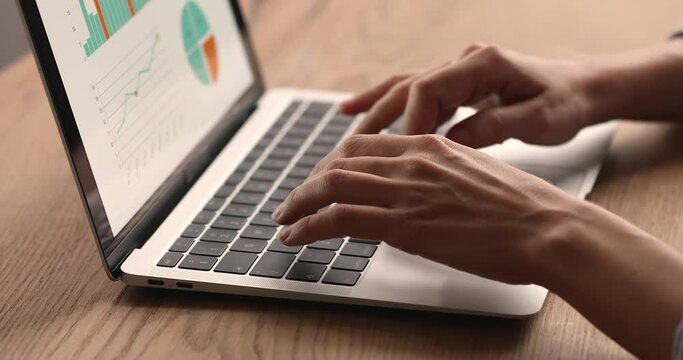 Work with stats using business software for financial data analysis, sales result, forecasting concept. Computer screen with graphs, diagrams, charts, female hands texting on laptop keyboard, close up