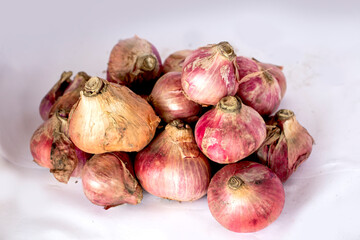 A bunch of onions and a white background behind it
