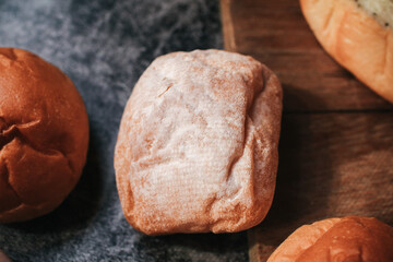 Homemade sourdough and bread bun. Freshly baked bread. Organic whole-wheat loaves. Simple breakfast on grey concrete background.	
