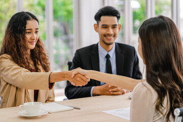 Closeup handshake after interview agreement between Young Asian woman and two manager with positive...