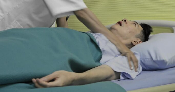 Man patient jerking and twitch in bad situation on bed in hospital while nurse and medical person try to help him. Concept of coma and emergency heart attacked.
