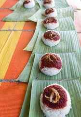 The packing of Nasi Lemak, rice cooked with coconut milk, a popular local dish in Malaysia. Selective focus points. Blurred background