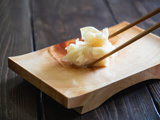 お寿司にかかせないガリ。木製の寿司下駄に乗せた、甘酢に漬けた生姜。