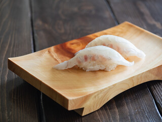 Fototapeta na wymiar 真鯛の握り寿司。木製の寿司下駄に乗せた、和食のお寿司。