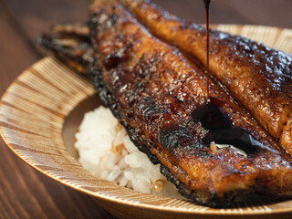 和食の鰻丼のクローズアップ。タレを付けてグリルした鰻をご飯の上に乗せた料理。