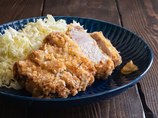 和食のとんかつのクローズアップ。豚肉に小麦粉と卵とパン粉を付けて揚げる料理。