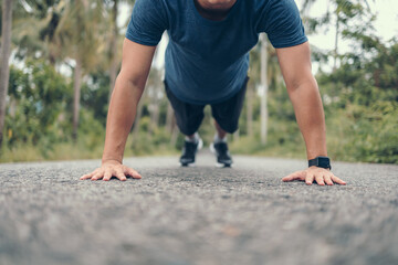 Young sportsman doing push-ups in the park. Fitness, training, workout concept.