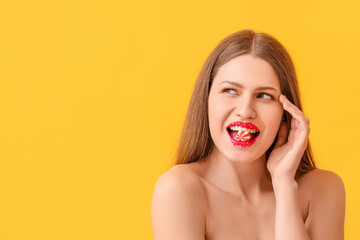 Beautiful young woman with creative makeup and candy on color background