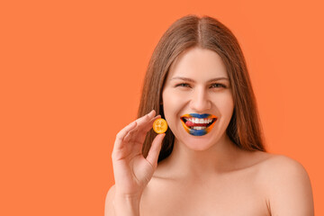 Beautiful young woman with creative makeup and cumquat on color background