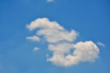 Beautiful cumulus clouds against the blue daytime sky.