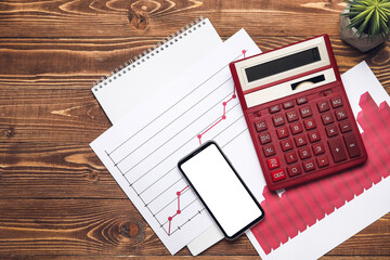 Composition with mobile phone and calculator on wooden background