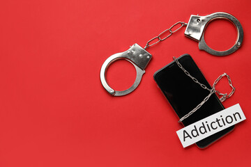 Mobile phone, handcuffs and word ADDICTION on color background