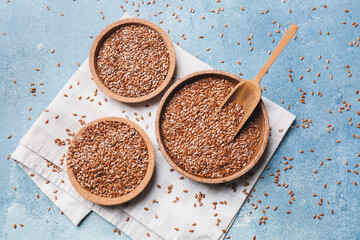 Composition with bowls of flax seeds on color background
